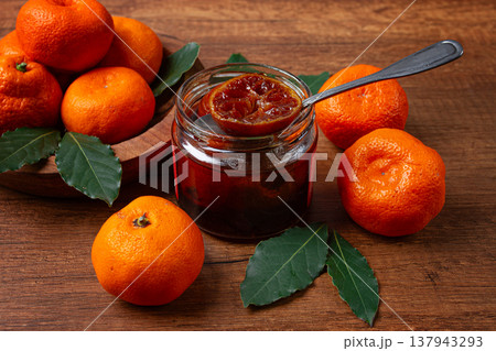 jar of tangerine jam, stands on a wooden table, with fresh tangerines, jar of tangerine jam, stands on a wooden table, with fresh tangerines, 137943293