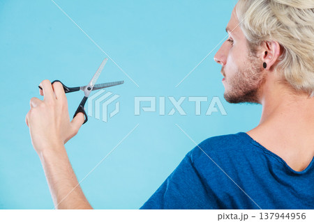 Man with scissors texturizing or thinning shears Man with scissors texturizing or thinning shears 137944956