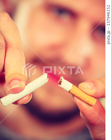 Young man is breaking a cigarette Young man is breaking a cigarette 137946152