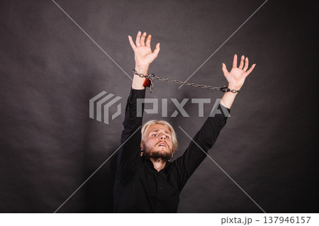 Furious man with chained hands, no freedom 137946157