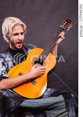 Blonde man playing acoustic guitar Blonde man playing acoustic guitar 137946162