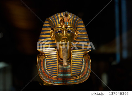 暗い背景に浮かぶツタンカーメン黄金マスクの正面クローズアップ 137946395