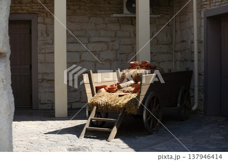 A wooden wagon is sitting in front of a building 137946414