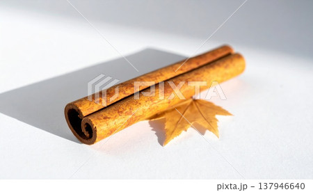 Aromatic Cinnamon Stick with Leaf on White Surface in Soft Lighting Studio Shot 137946640