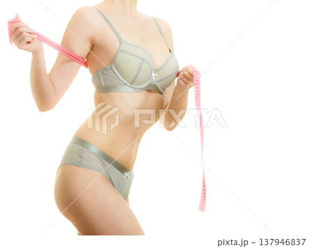 Woman in bra lingerie measuring her chest breasts. 137946837
