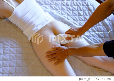 VIO脱毛をパートナー(彼氏、夫)に手伝ってもらう女性　うつ伏せ　家庭用脱毛器　トリミングアップ 137947060