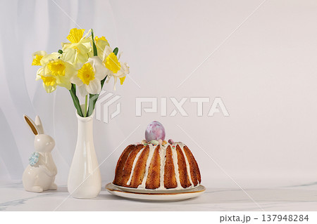 Easter celebration concept, Traditional Easter cake, Easter bunny figurines and spring daffodils in a vase on an elegant kitchen background, Easter dish ideas for home cooking, design template Easter celebration concept, Traditional Easter cake, Easter bunny figurines and spring daffodils in a vase on an elegant kitchen background, Easter dish ideas for home cooking, design template 137948284