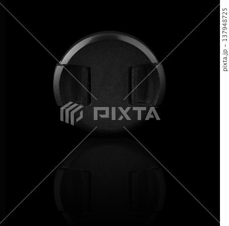 camera lens cap, on a black background with reflection 137948725