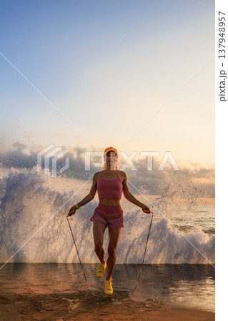Fit woman jumping rope at the beach during summer vacation 137948957