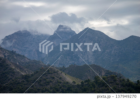 Scenic view of surrounding mountains and picturesque village from a hiking trail along an old irrigation ditch in Frigiliana, Spain. 137949270