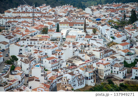 Scenic view of surrounding mountains and picturesque village from a hiking trail along an old irrigation ditch in Frigiliana, Spain. Scenic view of surrounding mountains and picturesque village from a hiking trail along an old irrigation ditch in Frigiliana, Spain. 137949271