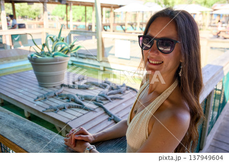 Woman observing baby alligators at wildlife park in Orlando Florida Woman observing baby alligators at wildlife park in Orlando Florida 137949604