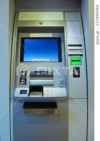 A full front view of an ATM machine in a banking lobby showing all the input and output components. A full front view of an ATM machine in a banking lobby showing all the input and output components. 137949764