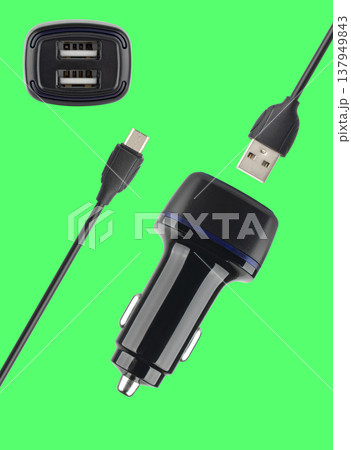 power adapter for the phone from the cigarette lighter, on a green background power adapter for the phone from the cigarette lighter, on a green background 137949843