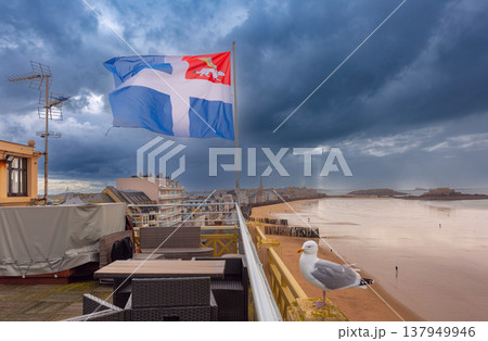 Breton flag over Saint Malo beach promenade and stormy coastline in Brittany France Breton flag over Saint Malo beach promenade and stormy coastline in Brittany France 137949946