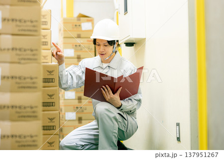 倉庫で在庫管理をする作業服の男性 倉庫で在庫管理をする作業服の男性 137951267