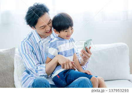 スマホを見る若い家族 137953293