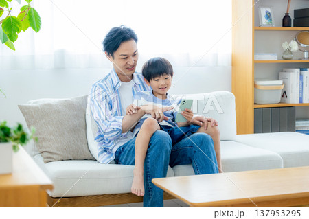 スマホを見る若い家族 137953295