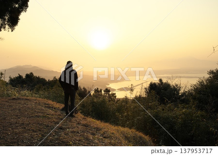 早春の早朝登山をする男性と日の出 早春の早朝登山をする男性と日の出 137953717