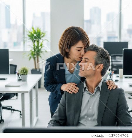 オフィスの中で男性にキスをする若い女性社員 137954701