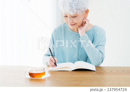 エンディングノートを書くシニア女性 エンディングノートを書くシニア女性 137954729