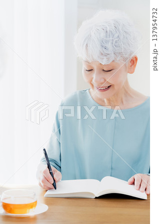 エンディングノートを書くシニア女性 エンディングノートを書くシニア女性 137954732