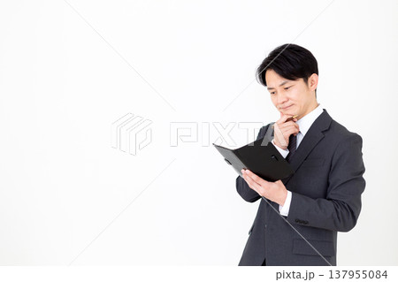 黒の手帳を持って悩むミドル男性ビジネスマン 137955084