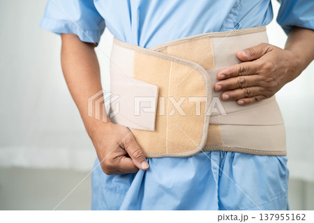 Asian senior pain back wearing elastic support belt with walker. Asian senior pain back wearing elastic support belt with walker. 137955162