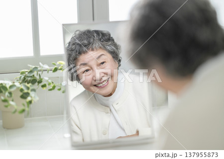 鏡を見ながら微笑む80代の女性 スキンケア・ビューティ イメージ 鏡を見ながら微笑む80代の女性 スキンケア・ビューティ イメージ 137955873