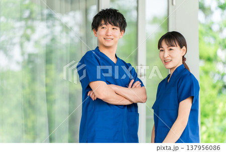 病院・施設の前にいるスクラブを着た医療従事者の男女スタッフ(理学療法士,看護師,技師) 病院・施設の前にいるスクラブを着た医療従事者の男女スタッフ(理学療法士,看護師,技師) 137956086