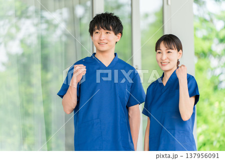 病院・施設の前にいるスクラブを着た医療従事者の男女スタッフ(ガッツポーズ,成功,応援) 病院・施設の前にいるスクラブを着た医療従事者の男女スタッフ(ガッツポーズ,成功,応援) 137956091