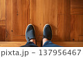 木の床に立つシューズの足元と室内の温かい空間 137956467
