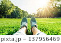芝生に座るスニーカーの足元と公園の爽やかな光 137956469