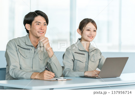 会議室で面談,面接,ミーティングをする作業着姿の男女スッタフ 会議室で面談,面接,ミーティングをする作業着姿の男女スッタフ 137956714