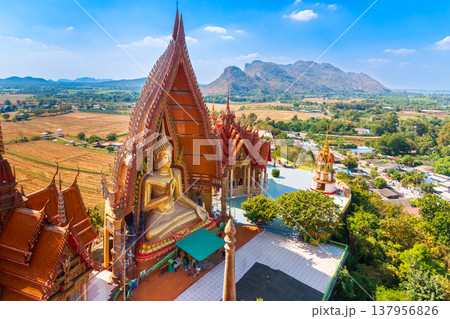 Giant Golden Buddha Statue at Wat Tham Suea with Scenic Landscape, Kanchanaburi, Thailand Giant Golden Buddha Statue at Wat Tham Suea with Scenic Landscape, Kanchanaburi, Thailand 137956826