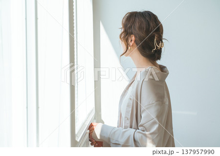 リビングの窓辺に立つおしゃれな女性 137957990