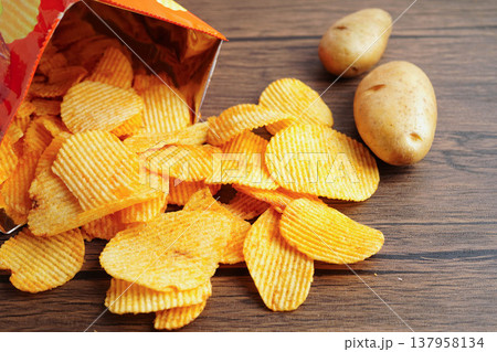 Potato chips in open bag, delicious BBQ seasoning spicy for crips, thin slice deep fried snack fast food. 137958134