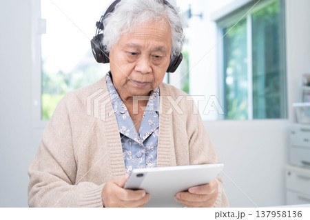Asian senior woman patient happy to use earphone to listen relax music. Asian senior woman patient happy to use earphone to listen relax music. 137958136