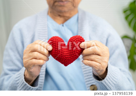 Asian elder senior woman patient holding red heart in hospital. Asian elder senior woman patient holding red heart in hospital. 137958139
