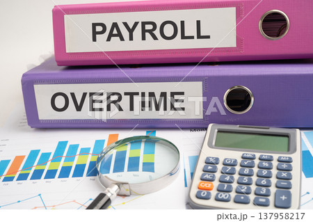 Payroll Overtime, binder with graph and calculator at office. Payroll Overtime, binder with graph and calculator at office. 137958217
