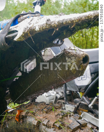 Muddy exhaust pipe of dirt bike. Close up of motorcycle after off road driving through dirt. Extreme sport and enduro race concept. Vehicle maintenance and cleaning repair service. Muddy exhaust pipe of dirt bike. Close up of motorcycle after off road driving through dirt. Extreme sport and enduro race concept. Vehicle maintenance and cleaning repair service. 137958840