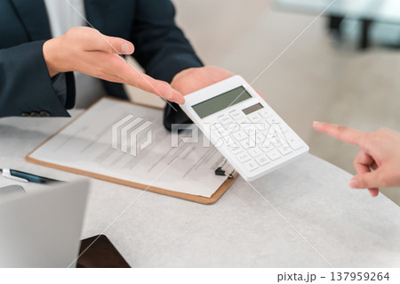 電卓の数字を提示する男性ビジネスマンの手元 137959264