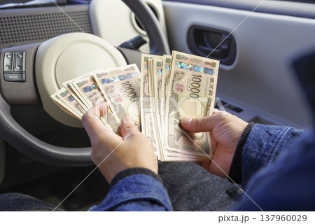 車内で現金を数える男性の手元 137960029