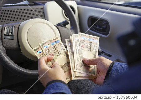 車内で現金を数える男性の手元 137960034