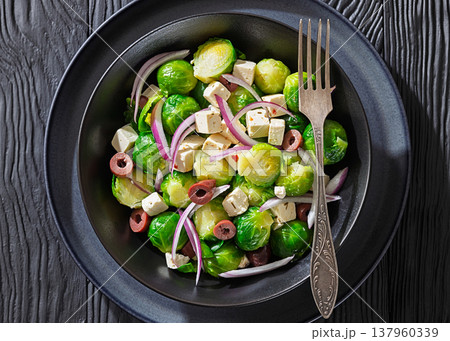 Mediterranean brussels sprouts salad with feta cheese, olives and red onion in black bowl Mediterranean brussels sprouts salad with feta cheese, olives and red onion in black bowl 137960339