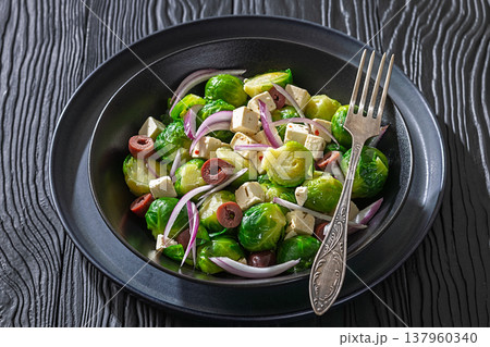 Mediterranean brussels sprouts salad with feta cheese, olives and red onion in black bowl Mediterranean brussels sprouts salad with feta cheese, olives and red onion in black bowl 137960340