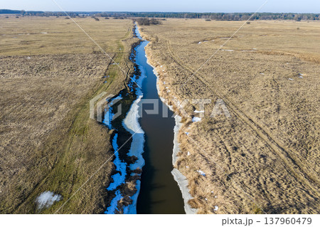 Narew river winding through vast thawing field Narew river winding through vast thawing field 137960479