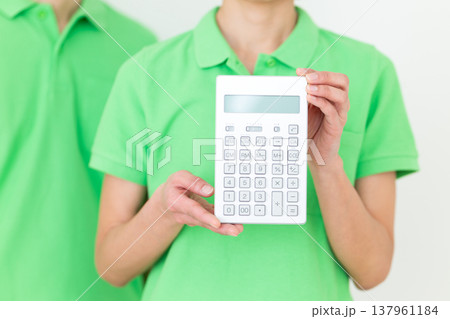 電卓を持つミドル女性の介護福祉士 電卓を持つミドル女性の介護福祉士 137961184