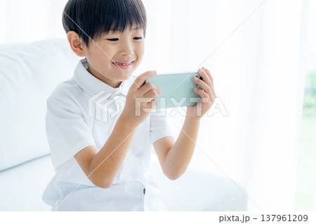 スマホを使う小学生の男の子 137961209