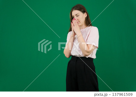 different emotions of a young girl on a green background chromakey beautiful facial features real people pink T-shirt white skinned European. black flared wide leg trousers 137961509